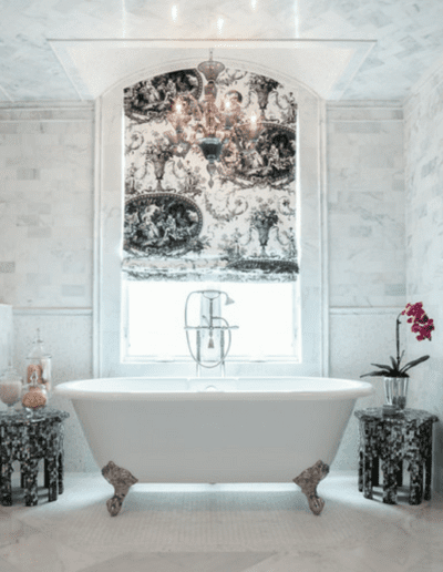 Luxurious bathroom with a freestanding tub, walk-in shower, and ornate window.