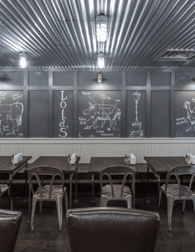 Modern restaurant interior with chalkboard wall art and industrial ceiling design.